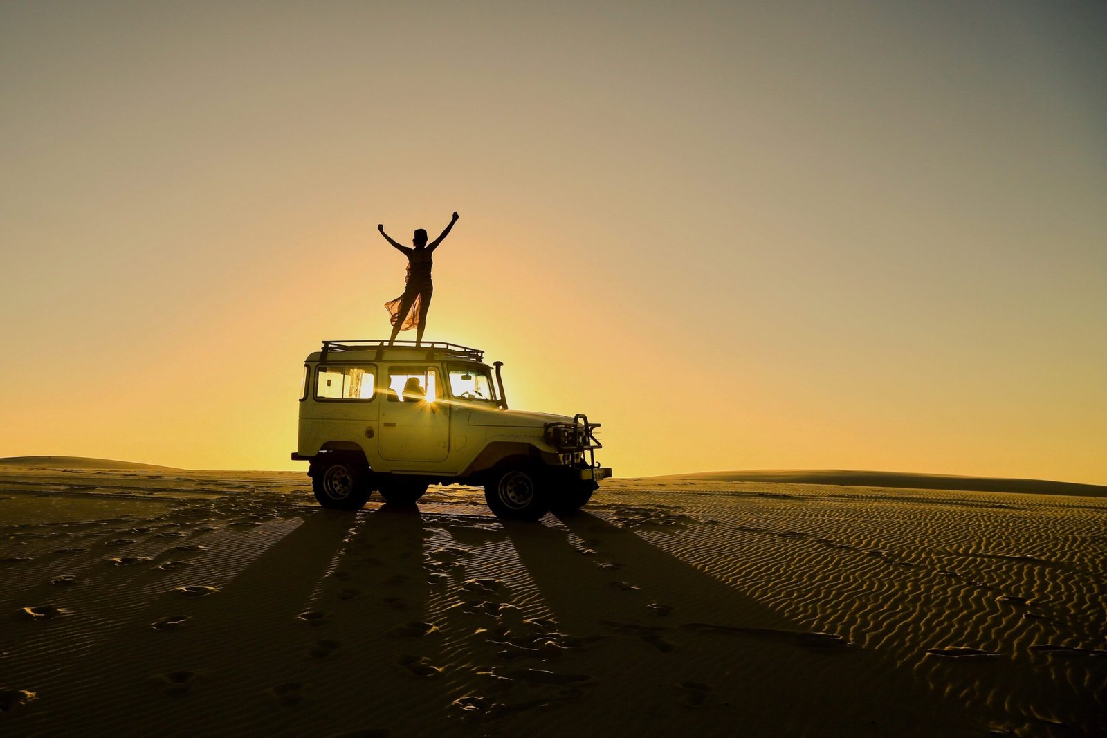 woman celebrating on top of offroad car